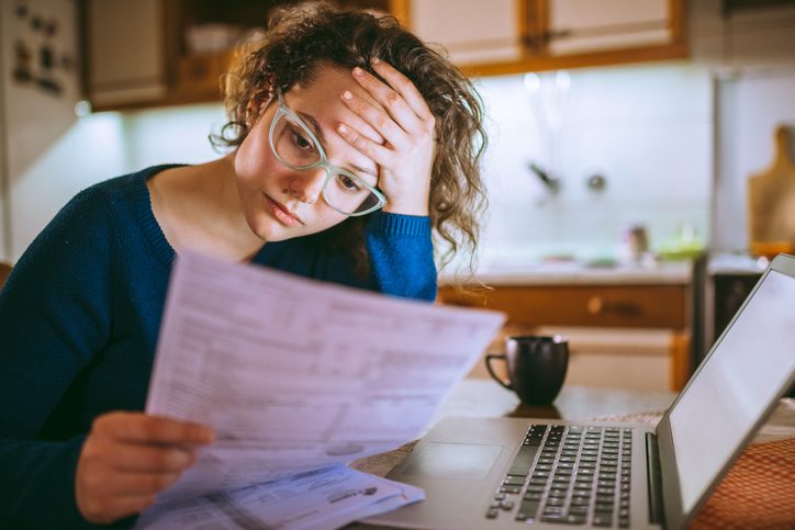 Martinson & Carter, CPAs, PA | woman looking at bills near laptop looking worried